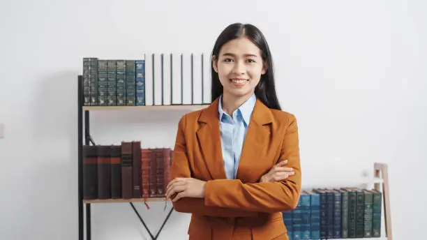 Photo of Young single female lawyer asian people in formal suit real estate working law book and contract documents, Arguments for Defense Strategy. Fight for Freedom. Supporting Evidence.