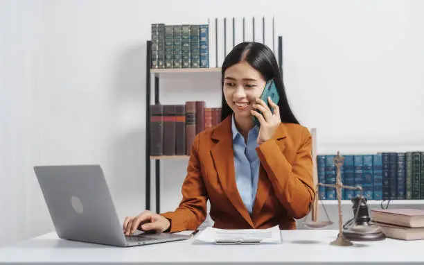 Photo of Young single female lawyer asian people in formal suit real estate working law book and contract documents, Arguments for Defense Strategy. Fight for Freedom. Supporting Evidence.