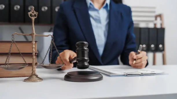 Photo of Young single female lawyer asian people in formal suit real estate working law book and contract documents, Arguments for Defense Strategy. Fight for Freedom. Supporting Evidence.