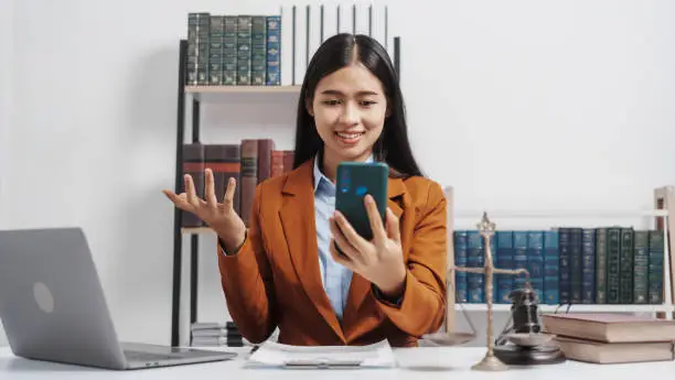 Photo of Young single female lawyer asian people in formal suit real estate working law book and contract documents, Arguments for Defense Strategy. Fight for Freedom. Supporting Evidence.