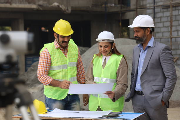 istock Hardworking Indian Site engineer and manager analysing the blueprint and figuring out the work in progress. Reporting the inspector. 1486241444
