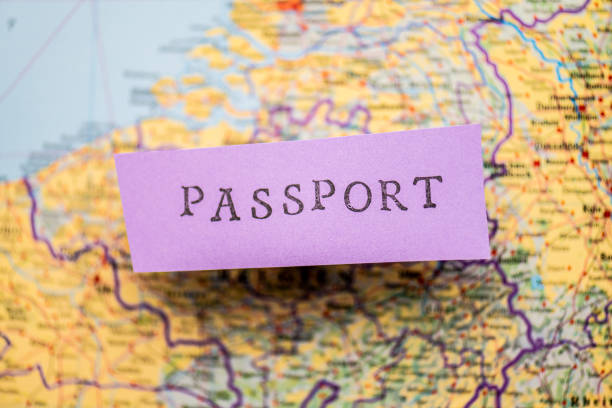 istock Passport stencil text on purple paper over a map.. 1486242878