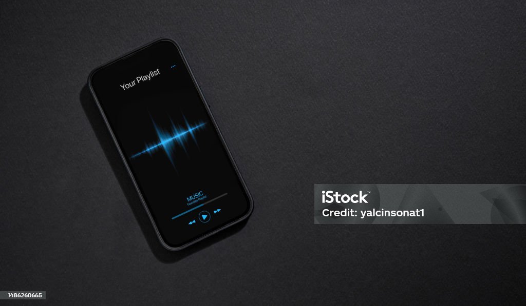 Smartphone with music player app open on screen on dark gray background Music Streaming Service Stock Photo