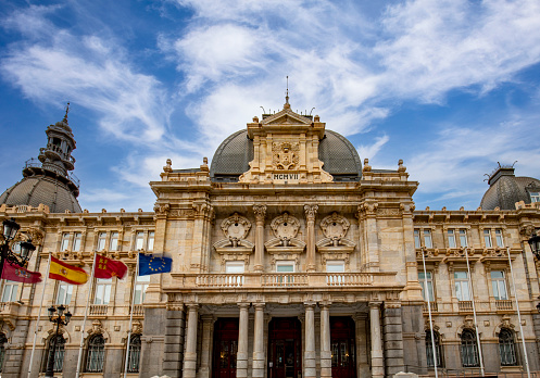 Facade of the town hall of Cartagena, Spain, in modernist style and with the flags of the Region of Murcia, Cartagena, Spain and Europe