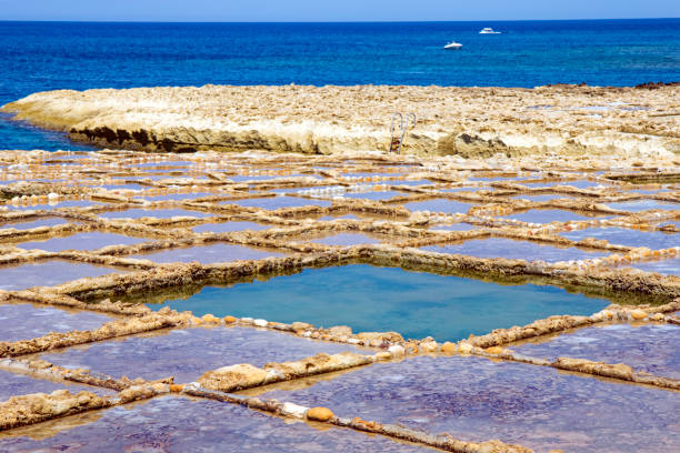 istock Blue colored pools with drying sea salt at Malta island. 1486272502