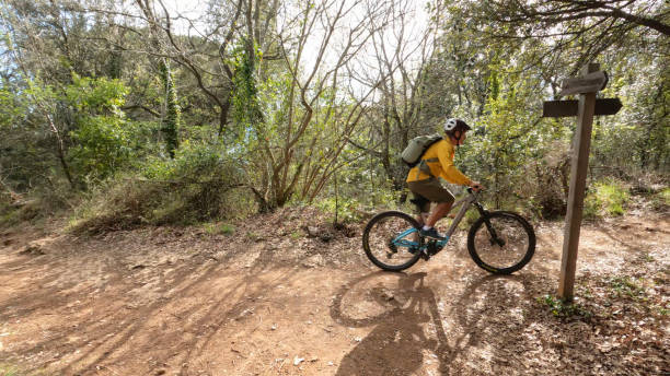 istock Senior male cyclist passes trail sign at trail fork 1486272763