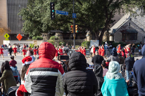 istock Diverse group of people in warm clothes jackets and live stream vlogger watching, broadcasting, streaming live street performance holiday event in Dallas, Texas, America 1486277023