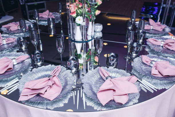 istock A chic mirror table served in a restaurant. Pink napkins on silver plates 1486278037