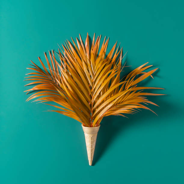 istock Creative summer or autumn concept. Palm leaves in a waffle cone on a blue background. 1486279609
