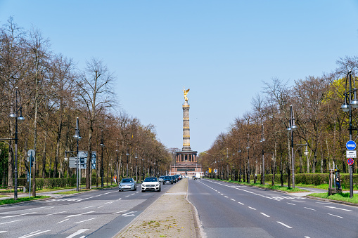 Berlin, Tiergarten district - cars moving along Hofjägerallee, Berlin Victory Column is on the background.