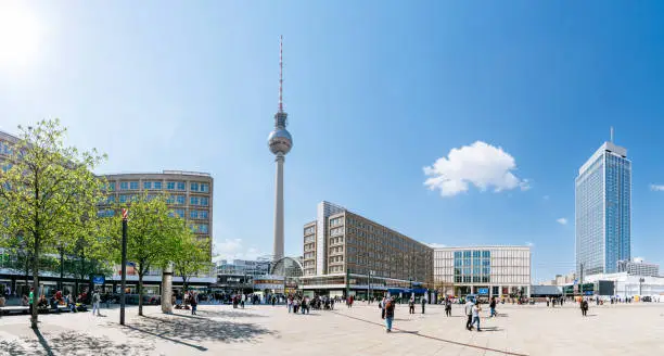 Berlin, Alexanderplatz in a sunny spring day. Park inn hotel, shopping malls, TV tower Fernsehturm and  Berlin Alexanderplatz Bahnhof are on the background.
