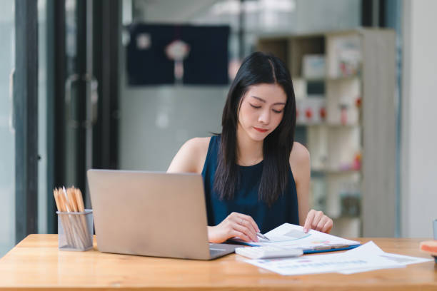 istock Professional millennial Accountant Woman in casuals working on financial analysis documents with a tense expression in the office. 1486286196