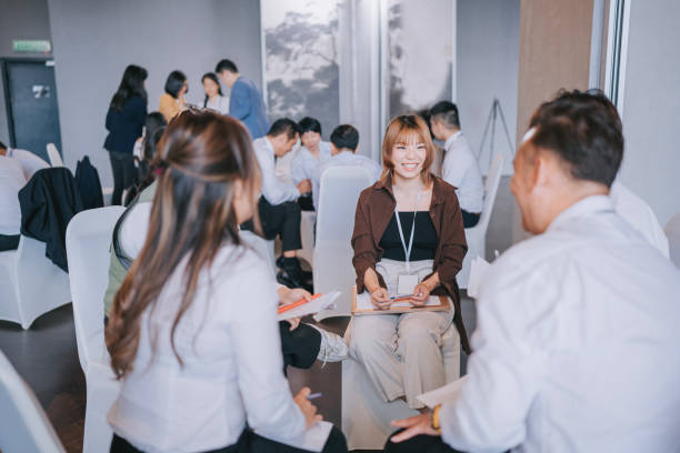istock Team building Asian workshop participants in small group discussion, brainstorming during business workshop class 1486286599