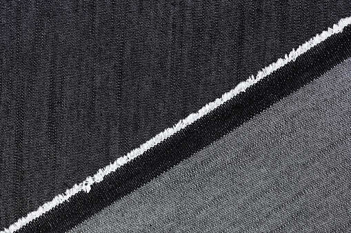 Close-up of black and grey jeans cloth textured background. Abstract material for clothing decoration concept