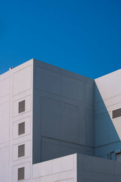 istock white modern geometric building with air vent on concrete wall surface against blue clear sky in vertical frame 1486302874
