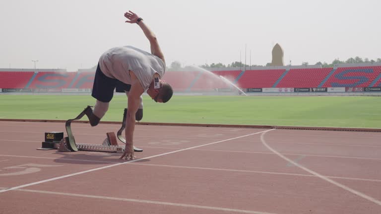 Sport man amputee athlete with prosthetic leg running on track.training for competition.slow motion day time.