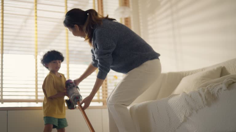 The boy enjoys helping his mother clean the house.