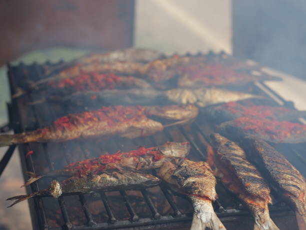 istock Selective focus of cooking fish. Baking and roasting marinated fish on barbecue grill. Thunnini grilled over charcoal. Summer barbeque hand marinade the fish. 1486311127