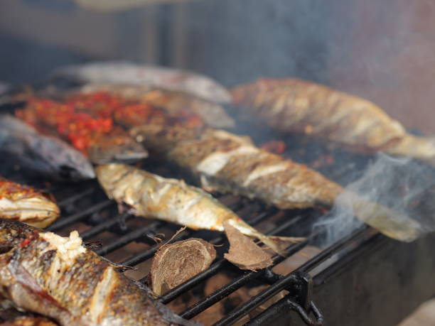 istock Selective focus of cooking fish. Baking and roasting marinated fish on barbecue grill. Thunnini grilled over charcoal. Summer barbeque hand marinade the fish. 1486311168