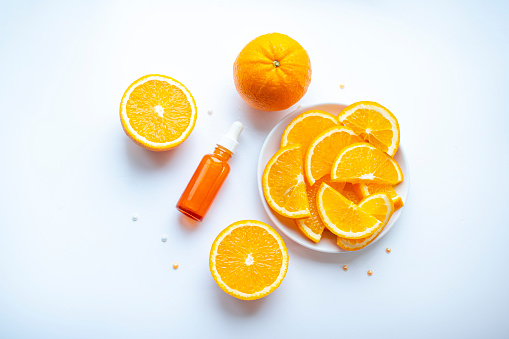 Stock photo showing heap of citrus fruit slices on white background, modern minimalist photo of circular sliced oranges, lemon and lime citrus fruits showing segments, seeds / pips and rind around edge, healthy eating concept photo for vitamin C and fruit juice.