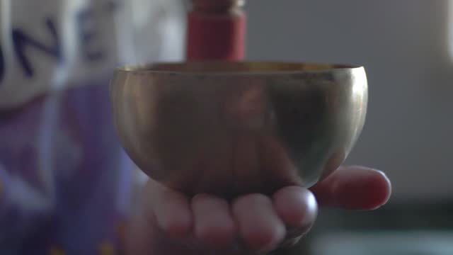 Female playing with Tibetan bowl in Slow motion