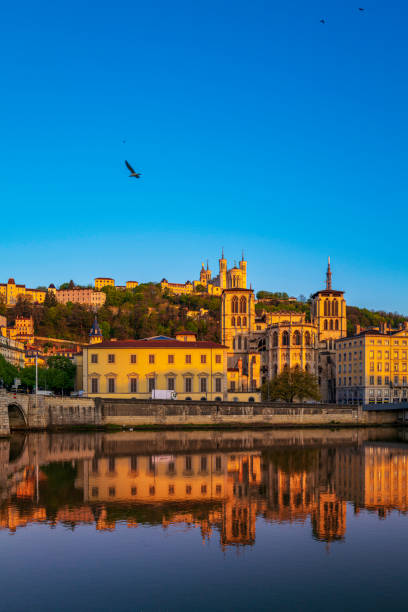 Lyon city skyline, buildings, and landmark architectures at sunrise with water reflections in the Saone River in France stock photo
