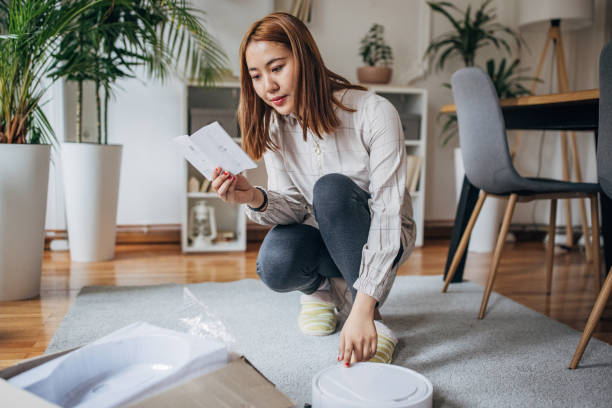 istock Young woman has new robotic vacuum cleaner 1486323966