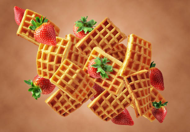 istock Belgian waffles with fresh strawberries in motion. 1486325874