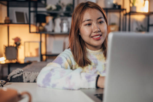 istock Asian woman using laptop at home 1486330412