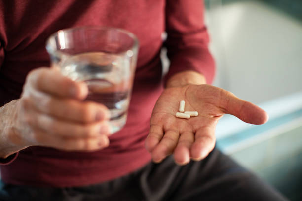 istock Senior man taking a pill in a bathroom 1486331406