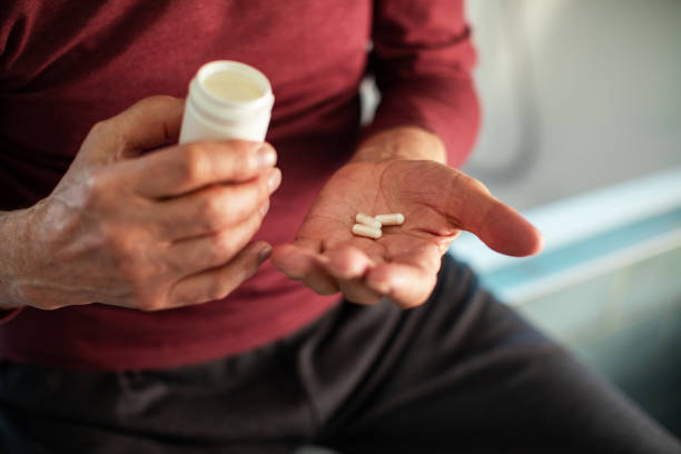 istock Senior man taking a pill in a bathroom 1486332717