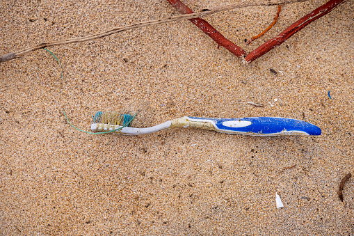 Trincomalee, Eastern Province, Sri Lanka - March 2nd 2023: Toothbrush of plastic washed ashore on the popular tropical beach north of the city