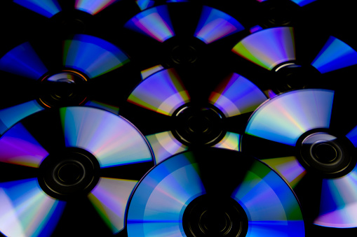 CD and DVD isolated on black background with colorful light reflections