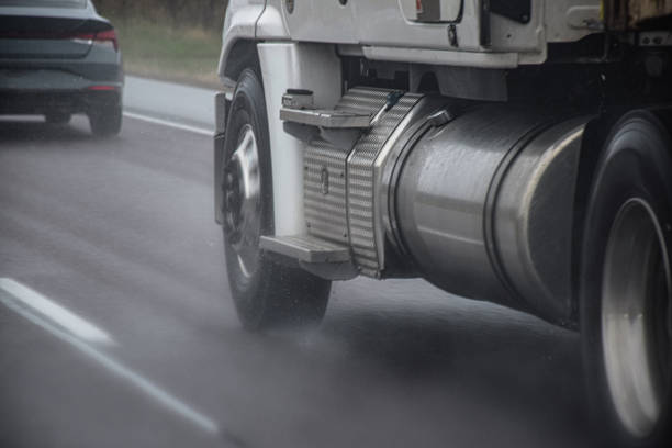 Toronto, Ontario, Canada - May 2, 2021: Wheels of tractor trailer driving at high speed on a highway during rain