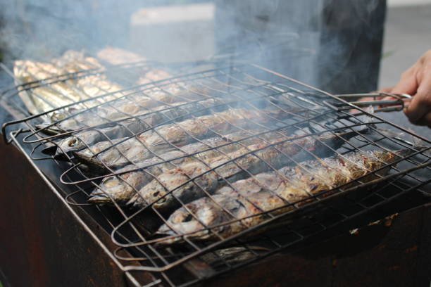 istock Close up of a man grilling fish 1486339971