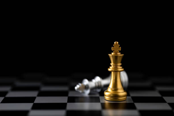 istock Golden king chess standing and silver king chess falling on chess board. 1486350890