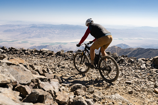 Backcountry Mountain Biking in the alpine tundra of White Mountains California.  A man in late 40’s riding up the 14’000 plus foot peak solo.