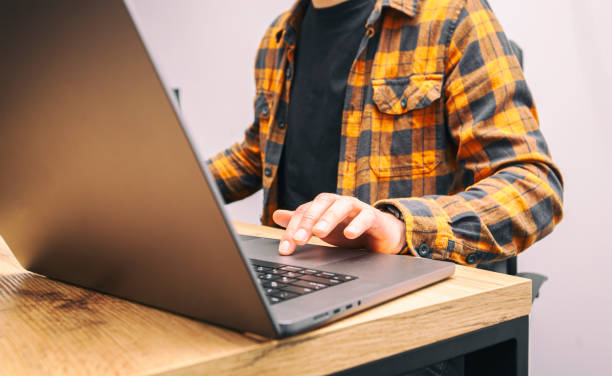 istock Young man working on laptop computer while sitting in coworking space. Freelance concept. 1486359242