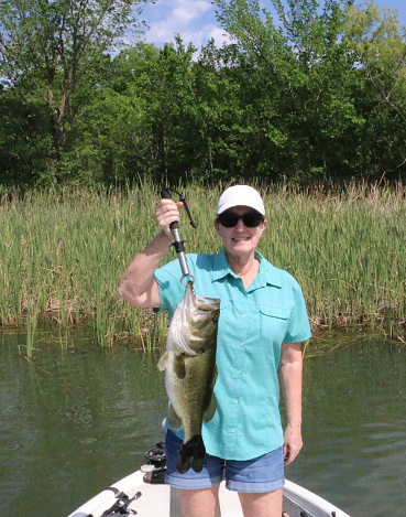 a woman holding a 5 pound 10 oz large mouth bass just caught