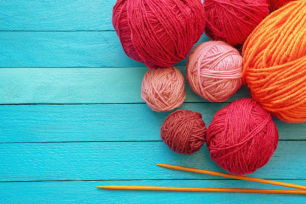 istock Hobbies and knitting concept. Balls of wool and  knitting needles on blue rustic table. Copy space 1486360695