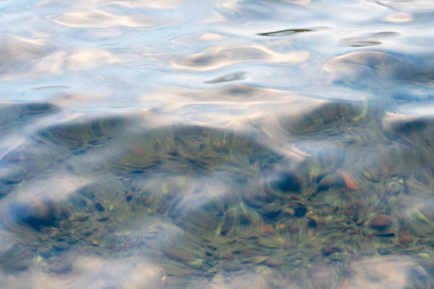 The crystal clear sea reveals the smooth pebbles at the bottom