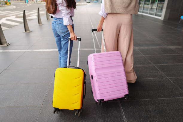 istock Female hands holds a yellow suitcase and pink suitcase on a bright background 1486362461