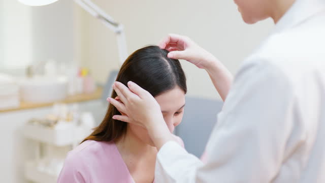 doctor examines scalp with hands