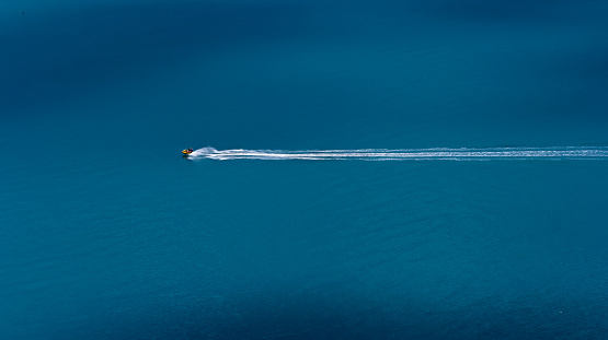 A trace from a jet ski at sea. Two men are riding during a summer vacation on a hot sunny day. View from above. Copy space.