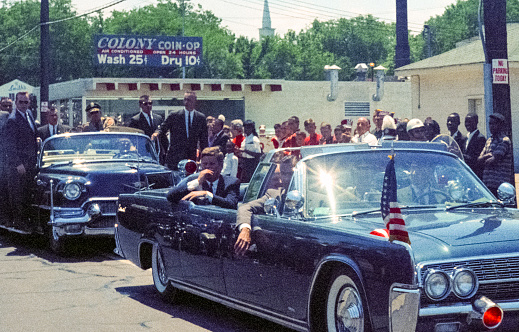 Nashville, Tennessee - May 18, 1963: Vintage nikon film scan of a photograph of President John F. Kennedy arriving for a campaign visit to Nashville's Vanderbilt University's Dudley Field on May 18, 1963 in the same 1961 Lincoln Continental convertible  that he was assassinated in six months later in Dallas.