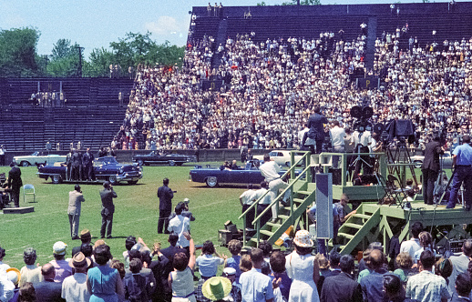 Nashville, Tennessee - May 18, 1963: Vintage nikon film scan of a photograph of President John F. Kennedy making a campaign visit to Nashville's Vanderbilt University's Dudley Field on May 18, 1963, arriving in the same 1961 Lincoln Continental convertible  that he was shot in six months later in Dallas.