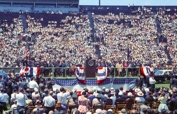 Nashville, Tennessee - May 18, 1963: Vintage nikon film scan of a photograph of President John F. Kennedy making a campaign visit to Nashville's Vanderbilt University's Dudley Field on May 18, 1963, arriving in the same 1961 Lincoln Continental convertible  that he was shot in six months later in Dallas.