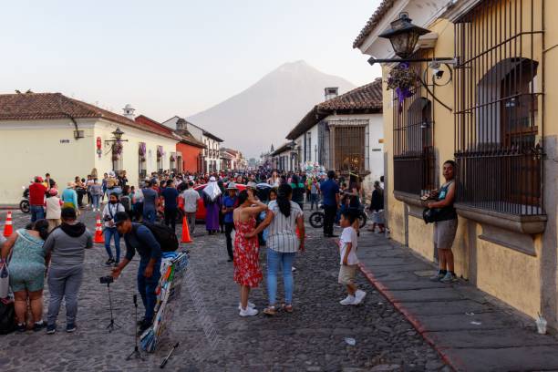 cityscape of the main street andvolcan de agua with lots of people walking around. - guatemala antigua central america color image imagens e fotografias de stock