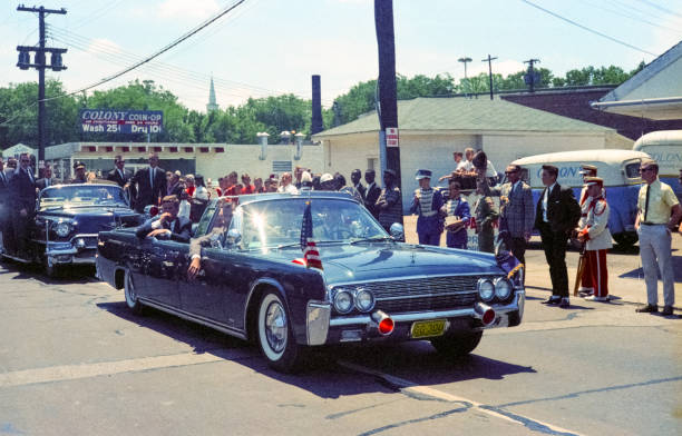 john f. kennedy in the presidential 1961 lincoln convertible - john f kennedy imagens e fotografias de stock