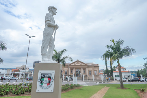 Vinhedo-sp,brazil-April 27,2023 immigrant museum in the background with sculpture representing the immigrant in front,statue symbol of the city of vinhedo sp.